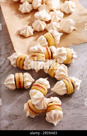 Meringue-Kekse mit Shortbread-Böden, Schokoladenaufstrich und roten Johannisbeeren Stockfoto