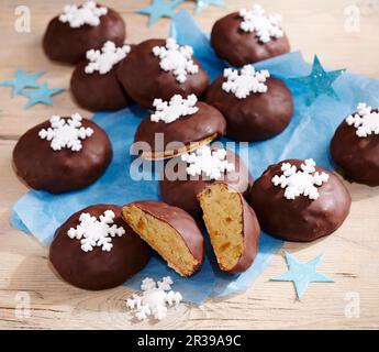 Zürcher Weihnachtskuchen mit Waffelbasen, Orangenschale, Marzipan, Schokoladenglasur und mit Schneeflocken verziert Stockfoto