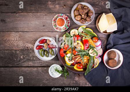 Set mit Käse und Snacks. Gegrillte Halloumi, belper knolle, Oliven, Tzatziki-Sauce auf altem rustikalem Holzhintergrund Stockfoto