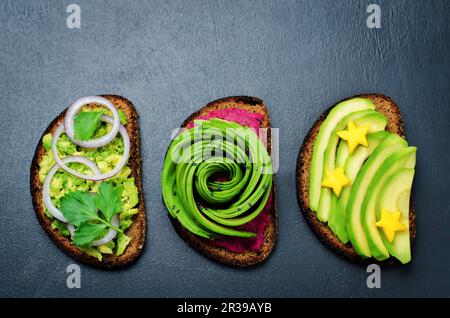 Variation von gesunden Roggen-Frühstückssandwiches mit Avocado und Toppings. Toning Stockfoto