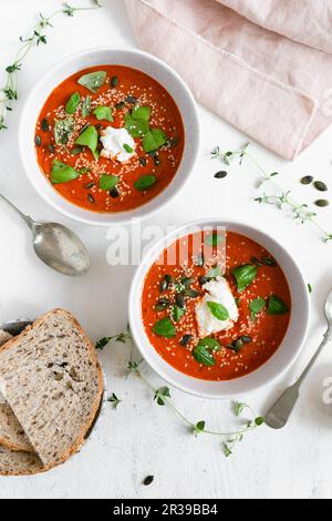 Zwei Schüsseln geröstete Tomatensuppe, garniert mit frischem Basilikum und Ricotta-Käse Stockfoto