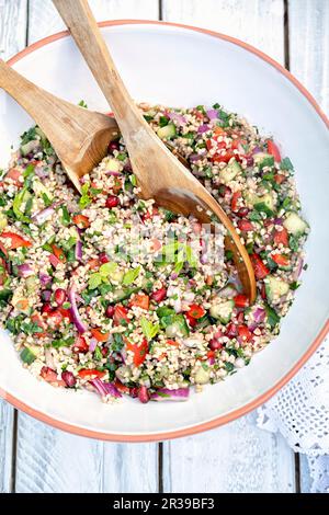 Große Schüssel libanesischer Tabbouleh-Salat mit Bulgur-Weizen, Tomaten, Gurke, Zwiebeln, Granatapfel Stockfoto