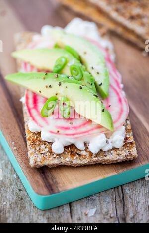 Gebackenes Knäckebrot mit Quark, gestreifter Rote Bete und Avocado Stockfoto