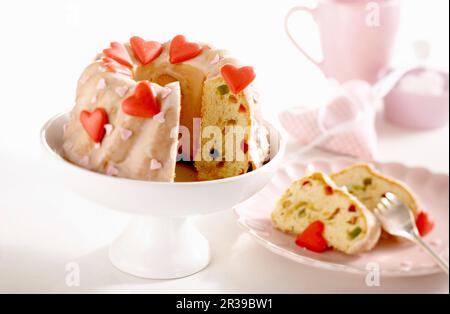 Kleine Limettenkuchen mit kandierten Früchten, Glasur und roten Herzen zum Muttertag Stockfoto