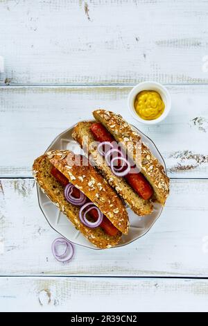 Köstliche hausgemachte Hot Dogs mit Zwiebeln, Gewürzen und Senf Stockfoto