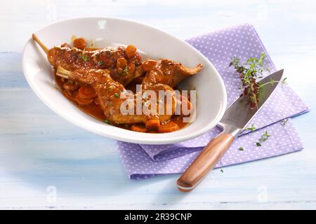 Geschmorte Hühnerschenkel mit Karotten Stockfoto