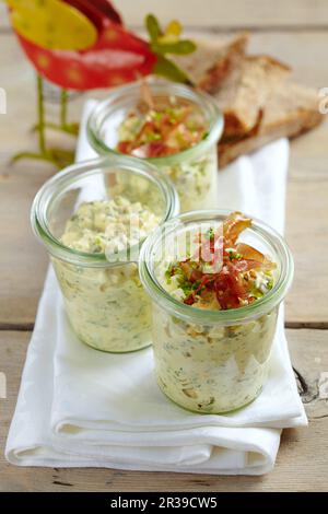 Eiersalat in Gläsern mit knusprigem gebratenem Parmaschinken für einen Osterbrunch Stockfoto