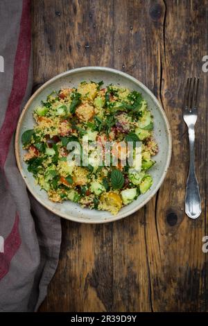 Tabbouleh (Couscous-Salat mit Tomaten, Gurken, roten Zwiebeln, Petersilie und Minze) Stockfoto