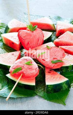 Herzförmiges Wassermelonen-Eis am Stiel auf Scheiben Wassermelone Stockfoto