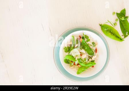 Glasnudeln mit Mangetout, Goji-Beeren und Erdnüssen (Draufsicht) Stockfoto