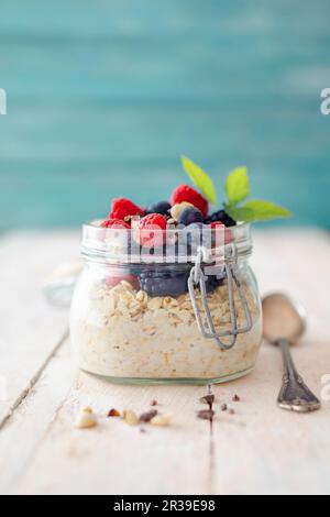 Hafer über Nacht mit frischen Beeren in einem Klappbecher Stockfoto