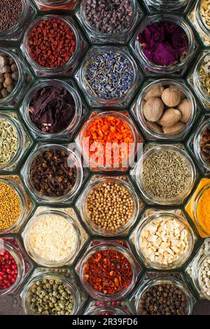 Verschiedene bunte Gewürze und Kräuter in Flaschen Stockfoto