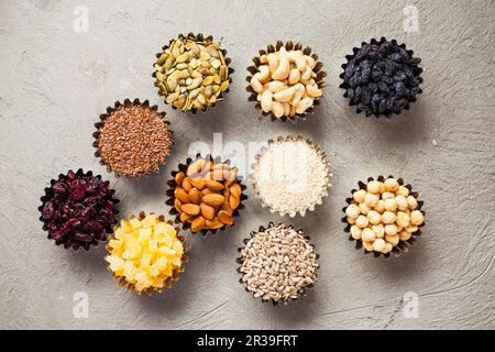 Set mit Schalen mit gesunden Trockenfrüchten und leckeren Nüssen Stockfoto