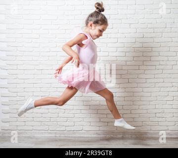 Die kleine Ballerina in einem Trikot springt Stockfoto