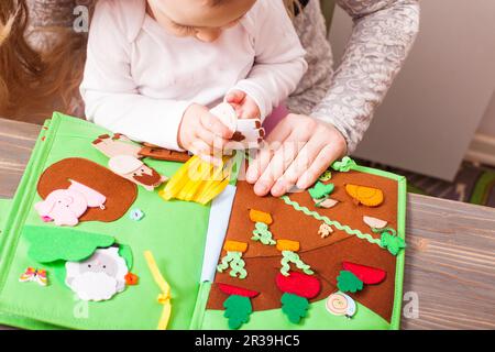 Das Kindermädchen unterrichtet ein kleines Mädchen im Kindergarten Stockfoto