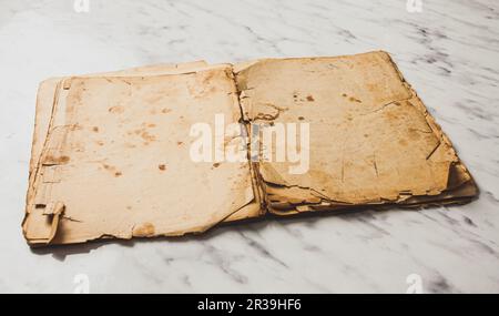 Eröffnetes Vintage-Buch auf Marmortisch mit leeren Seiten Stockfoto