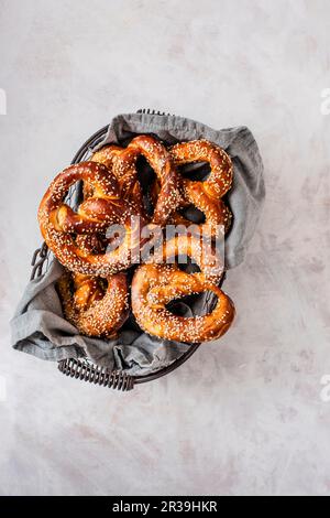 Hausgemachte Brezeln mit Seesamen in einem Drahtkorb Stockfoto