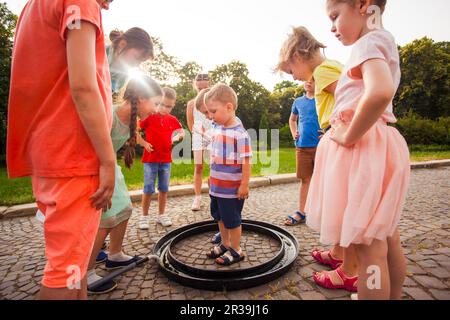 Süßer kleiner Junge, der in einer großen Seifenblase steht Stockfoto