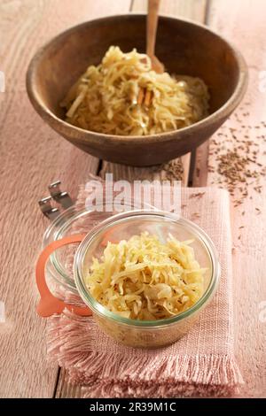 Sauerkraut aus Spitzkohl in einer Holzschüssel und einem Glas Stockfoto