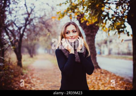 Hübsches Mädchen im Teenager-Alter mit langen Haaren. Schöne junge Frau, die im Herbst im Freien spazieren geht. Stockfoto