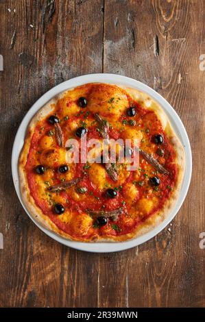 Pizza Napoli mit Sardellen und Oliven Stockfoto
