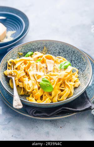 Tagliatelle mit cremigem Butternusskürbis, Parmesan und Basilikum Stockfoto