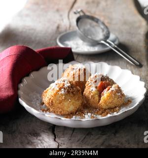 In Butter geröstete Damonklöße mit Brotkrumen und Puderzucker Stockfoto