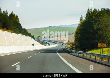 Autos, die auf der Asphaltstraße durch den Berg fahren Stockfoto