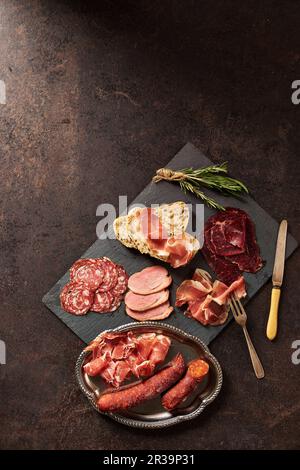 Auswahl an Wurstwaren mit Brot und Rosmarin Stockfoto