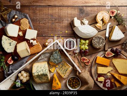 Auswahl an Käse mit Obst, Crackern, Kräutern und Chutney Stockfoto