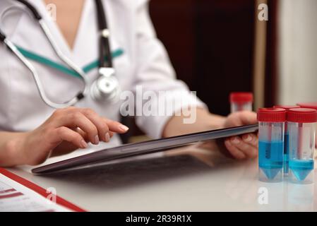 Der Arzt untersucht eine Röntgenaufnahme des Patienten auf dem Touchpad. Schließen Stockfoto