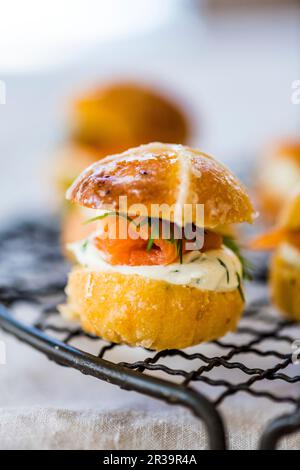 Herzhafter Hot Cross Bun Burger mit Lachs und Frischkäse Stockfoto