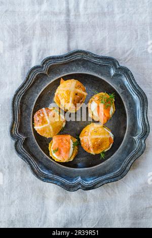 Herzhafter Hot Cross Bun Burger mit Lachs und Frischkäse Stockfoto