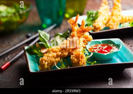 Garnelen Tempura mit scharfer Chilisauce auf blauem Teller. Meeresfrüchte-Tempura-Gericht mit traditioneller asiatischer Küche. Stockfoto