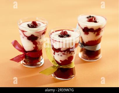 Dessert mit geschmorten Himbeeren, Brombeeren, Blaubeeren, roten Johannisbeeren, schwarzen Johannisbeeren gemischt mit Joghurt Stockfoto