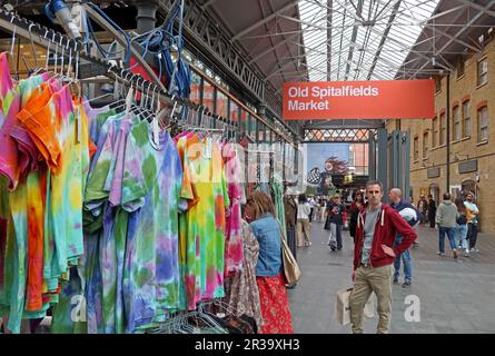 In der überdachten Halle des Old Spitalfields Market in East London werden bunte neue Kleidungsstücke verkauft Stockfoto