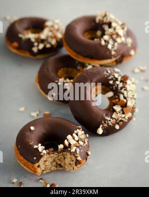 Haselnuss-Donuts mit Schokoladenglasur und gehackten Haselnüssen Stockfoto