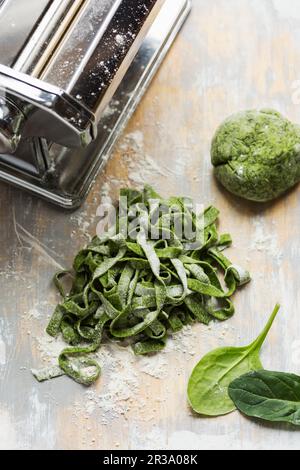 Nudelteig mit Spinat, hausgemacht in Tagliatelle geschnitten, mit Teig und Nudelautomat Stockfoto