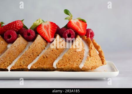 Sommerlicher Kokosnusskuchen mit Glasur, Himbeeren und Erdbeeren Stockfoto