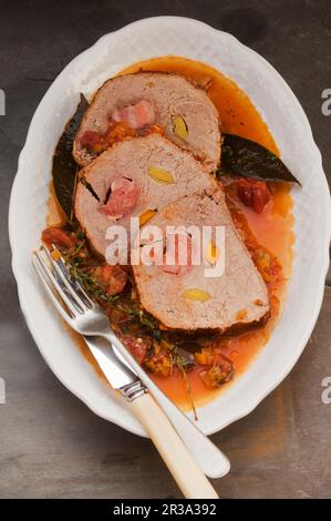 Gefüllte Schweinefleisch-Roulade in Gemüsebrühe Stockfoto