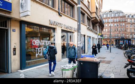 Straßburg, Frankreich - 20. März 2023: Die beschädigte Fassade der Monte Paschi Banque, geschmückt mit Schildern und Aufklebern, zeugt von dem anhaltenden Protest gegen die staatliche Rentenreform in einer belebten Straße in einer Stadt. Stockfoto