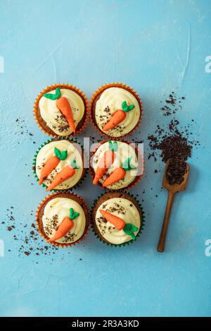 Karottenkuchen-Cupcakes mit Orangencreme-Käseeis und zerkleinerten Keksen Stockfoto