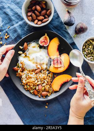 Joghurtschale mit Müsli, Nüssen und Obst Stockfoto