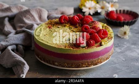 Veganer roher Cashew-Kuchen mit Himbeeren, Kokosnussbutter und Kokosmilch sowie Basis aus Mandeln, Datteln Stockfoto