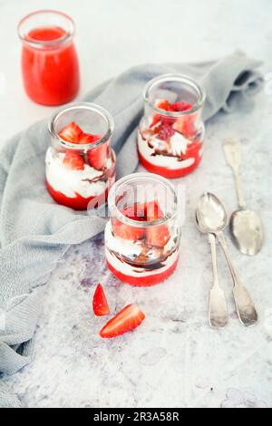 Kleine Desserts mit Joghurt, Erdbeermousse und Schokoladenglasur Stockfoto