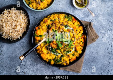 Veganischer Dal mit roten Linsen, Kürbis, Kichererbsen und Spinat in einer Schüssel mit Reis (Indien) Stockfoto