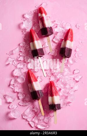 Hausgemachte dreifarbige Eislollies (Erdbeere, Banane und Heidelbeere) Stockfoto