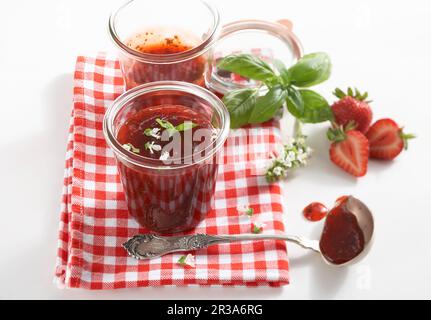 Erdbeermarmelade mit frischen Basilikumblättern Stockfoto