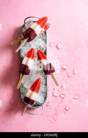 Hausgemachte dreifarbige Eislollies (Erdbeere, Banane und Heidelbeere) Stockfoto