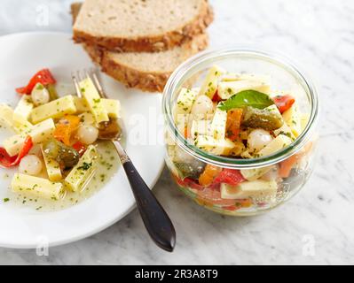Würziger eingelegter Emmentaler Käse in Essig und Öl, Gewürzgurken, Perlzwiebeln und Paprika Stockfoto